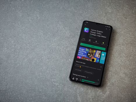Lod, Israel - July 8, 2020: Canva - Graphic Design app play store page on the display of a black mobile smartphone on ceramic stone background. Top view flat lay with copy space. 