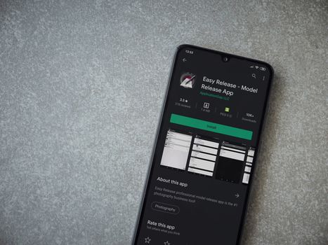 Lod, Israel - July 8, 2020: Easy Release Pro - Model Release app play store page on the display of a black mobile smartphone on ceramic stone background. Top view flat lay with copy space. 