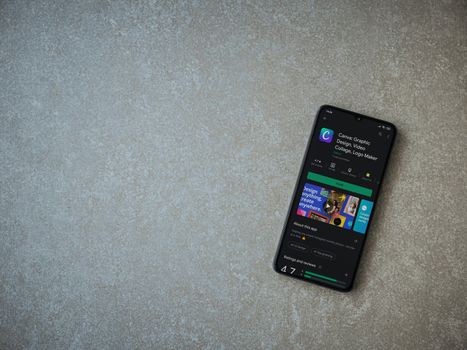 Lod, Israel - July 8, 2020: Canva - Graphic Design app play store page on the display of a black mobile smartphone on ceramic stone background. Top view flat lay with copy space. 