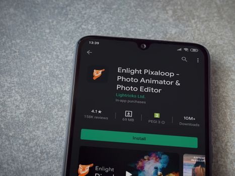 Lod, Israel - July 8, 2020: Enlight Pixaloop app play store page on the display of a black mobile smartphone on ceramic stone background. Top view flat lay with copy space.
