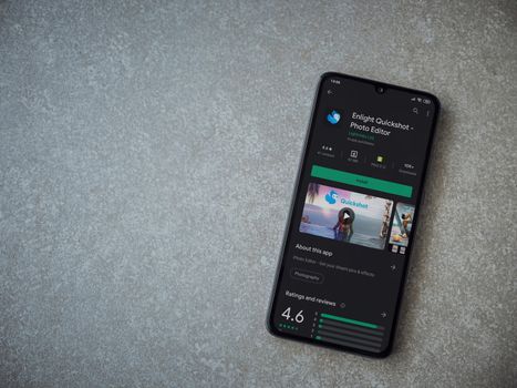 Lod, Israel - July 8, 2020: Enlight Quickshot app play store page on the display of a black mobile smartphone on ceramic stone background. Top view flat lay with copy space.