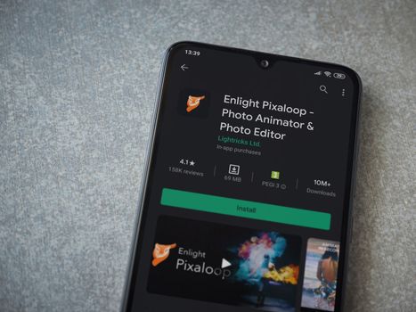 Lod, Israel - July 8, 2020: Enlight Pixaloop app play store page on the display of a black mobile smartphone on ceramic stone background. Top view flat lay with copy space.