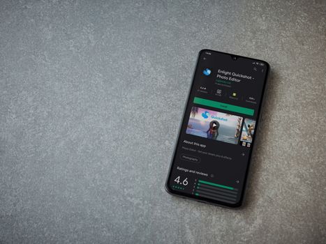 Lod, Israel - July 8, 2020: Enlight Quickshot app play store page on the display of a black mobile smartphone on ceramic stone background. Top view flat lay with copy space.