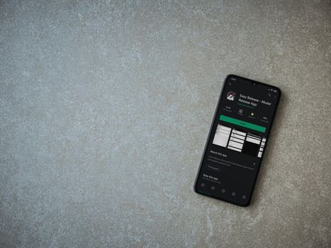 Lod, Israel - July 8, 2020: Easy Release Pro - Model Release app play store page on the display of a black mobile smartphone on ceramic stone background. Top view flat lay with copy space. 