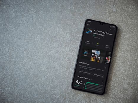 Lod, Israel - July 8, 2020: GoPro - Video Editor and Movie Maker app play store page on the display of a black mobile smartphone on ceramic stone background. Top view flat lay with copy space.