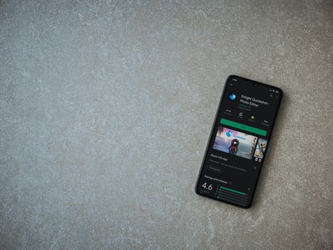 Lod, Israel - July 8, 2020: Enlight Quickshot app play store page on the display of a black mobile smartphone on ceramic stone background. Top view flat lay with copy space.