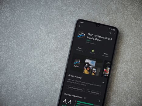 Lod, Israel - July 8, 2020: GoPro - Video Editor and Movie Maker app play store page on the display of a black mobile smartphone on ceramic stone background. Top view flat lay with copy space.