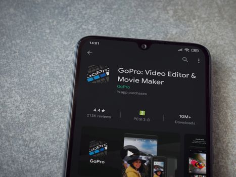 Lod, Israel - July 8, 2020: GoPro - Video Editor and Movie Maker app play store page on the display of a black mobile smartphone on ceramic stone background. Top view flat lay with copy space.