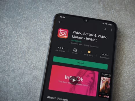 Lod, Israel - July 8, 2020: InShot - Video Editor and Movie Maker app play store page on the display of a black mobile smartphone on ceramic stone background. Top view flat lay with copy space.