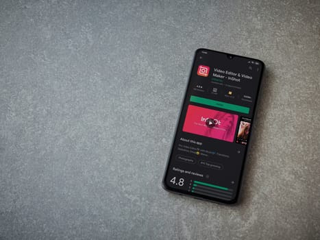 Lod, Israel - July 8, 2020: InShot - Video Editor and Movie Maker app play store page on the display of a black mobile smartphone on ceramic stone background. Top view flat lay with copy space.