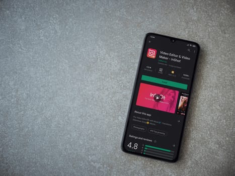 Lod, Israel - July 8, 2020: InShot - Video Editor and Movie Maker app play store page on the display of a black mobile smartphone on ceramic stone background. Top view flat lay with copy space.