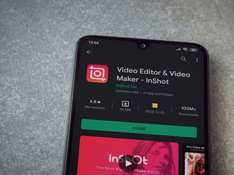 Lod, Israel - July 8, 2020: InShot - Video Editor and Movie Maker app play store page on the display of a black mobile smartphone on ceramic stone background. Top view flat lay with copy space.