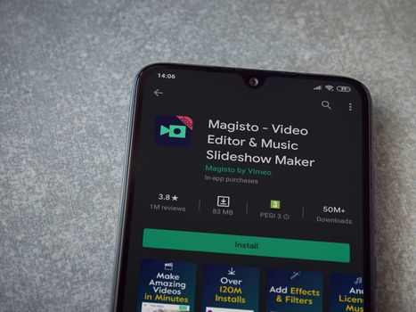 Lod, Israel - July 8, 2020: Magisto - Video Editor and Movie Maker app play store page on the display of a black mobile smartphone on ceramic stone background. Top view flat lay with copy space.