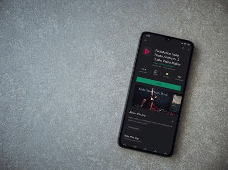 Lod, Israel - July 8, 2020: PixaMotion app play store page on the display of a black mobile smartphone on ceramic stone background. Top view flat lay with copy space.
