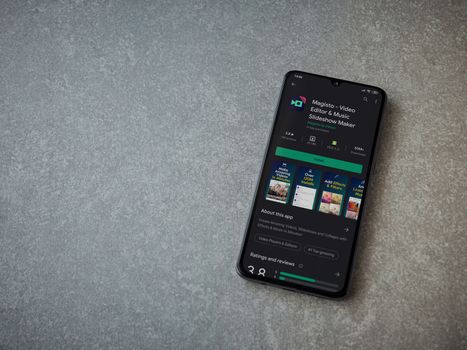 Lod, Israel - July 8, 2020: Magisto - Video Editor and Movie Maker app play store page on the display of a black mobile smartphone on ceramic stone background. Top view flat lay with copy space.