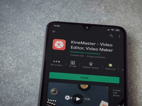 Lod, Israel - July 8, 2020: KineMaster - Video Editor and Movie Maker app play store page on the display of a black mobile smartphone on ceramic stone background. Top view flat lay with copy space.
