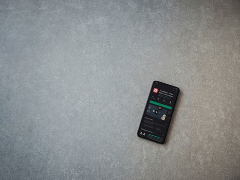 Lod, Israel - July 8, 2020: KineMaster - Video Editor and Movie Maker app play store page on the display of a black mobile smartphone on ceramic stone background. Top view flat lay with copy space.