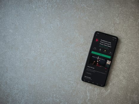 Lod, Israel - July 8, 2020: PixaMotion app play store page on the display of a black mobile smartphone on ceramic stone background. Top view flat lay with copy space.