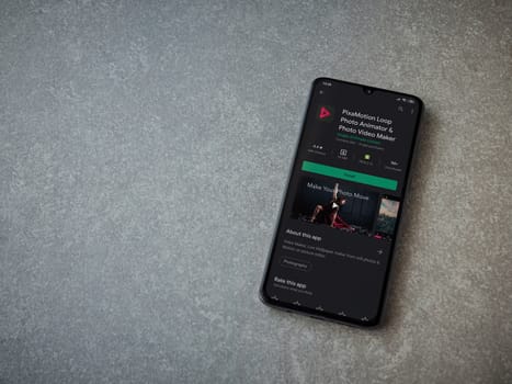 Lod, Israel - July 8, 2020: PixaMotion app play store page on the display of a black mobile smartphone on ceramic stone background. Top view flat lay with copy space.