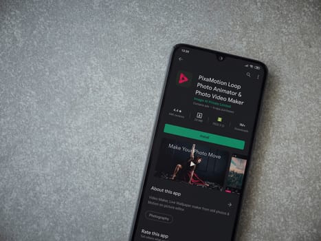 Lod, Israel - July 8, 2020: PixaMotion app play store page on the display of a black mobile smartphone on ceramic stone background. Top view flat lay with copy space.