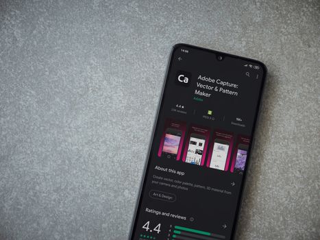 Lod, Israel - July 8, 2020: Adobe Capture - Vector and Pattern Maker app play store page on the display of a black mobile smartphone on ceramic stone background. Top view flat lay with copy space.