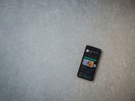 Lod, Israel - July 8, 2020: VSCO - Photo and Video Editor app play store page on the display of a black mobile smartphone on ceramic stone background. Top view flat lay with copy space. 