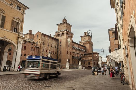 FERRARA, ITALY 29 JULY 2020 : Evocative view of the castle of Ferrara with people and tourists passing by on the street in front