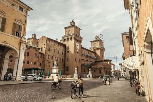 FERRARA, ITALY 29 JULY 2020 : Evocative view of the castle of Ferrara with people and tourists passing by on the street in front