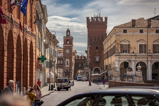 FERRARA, ITALY 29 JULY 2020 : Evocative view of the road leading to the historic center of Ferrara with a view of the castle and life on the road