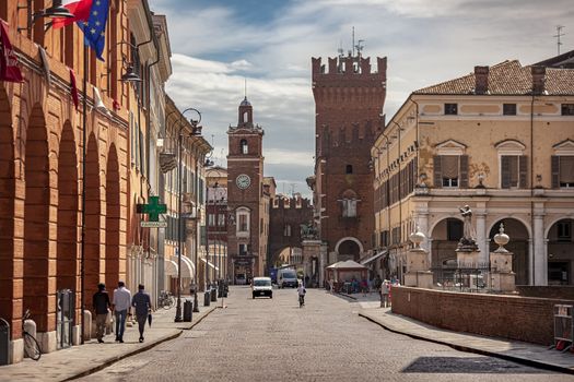 FERRARA, ITALY 29 JULY 2020 : Evocative view of the road leading to the historic center of Ferrara with a view of the castle and life on the road