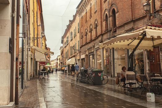 FERRARA, ITALY 29 JULY 2020 : Alley with people walking in Ferrara in Italy