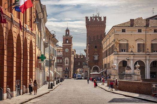 FERRARA, ITALY 29 JULY 2020 : Evocative view of the road leading to the historic center of Ferrara with a view of the castle and life on the road