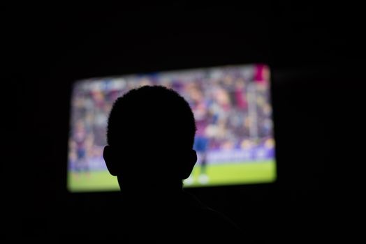 Person watching television in dark room