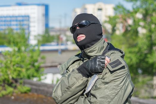 A bandit in a mask and black glasses rests and looks at the sun