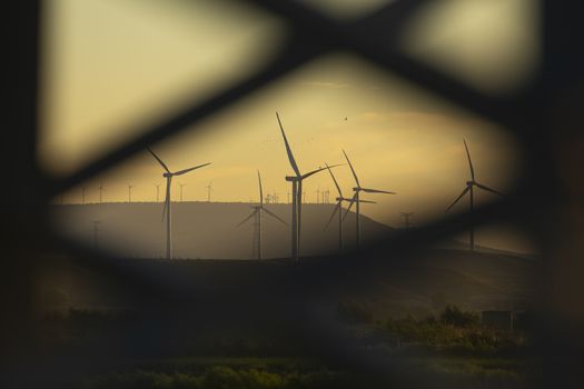 Blurred wind turbines in the distance under the heat of a summer afternoon in the community of Aragon, Spain.