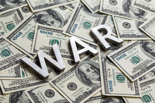 a word war laid by metal letters on dollar banknotes background - for military business concept