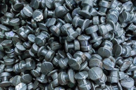 An abstract industrial full frame background of forged and sanded steel billets. Close-up with selective focus and optical blur.
