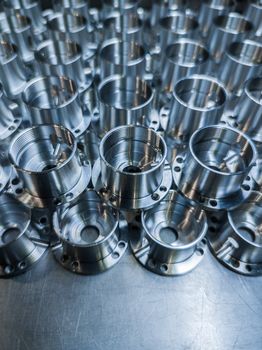 a batch of shiny metal cnc aerospace parts production - close-up with selective focus for industrial full frame manufacturing background.