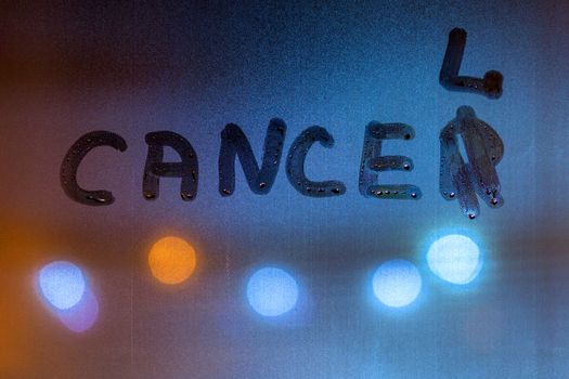The word work out written on night sweaty window glass with blurred blue light in the background.