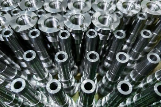 Shiny steel parts close-up background, long clean steel rods after fine cnc turning.