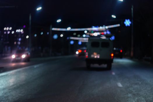 Defocused picture of night street car traffic - view from road. Colorful night life dark background.
