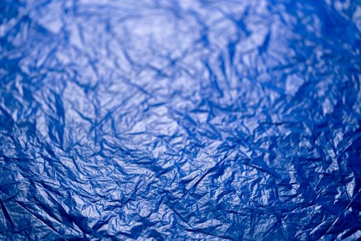 crumpled blue polyethilene film abstract background with selective focus.