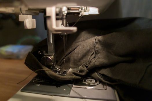 a dark gomestic sewing with machine and green military cloth.