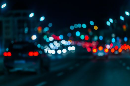 Defocused picture of night street car traffic - view from road. Colorful night life dark background.