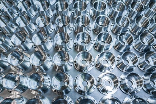 a batch of shiny metal cnc aerospace parts production - close-up with selective focus for industrial full frame background.