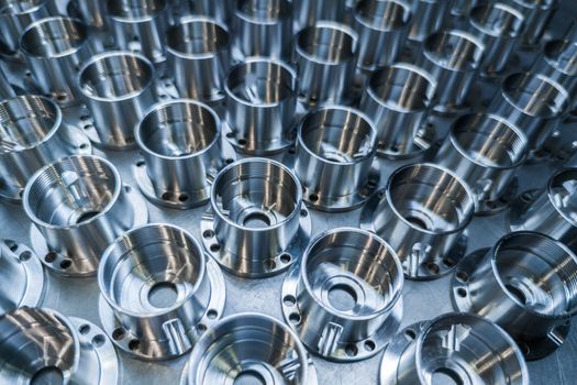 a batch of shiny metal cnc aerospace parts production - close-up with selective focus for industrial background.