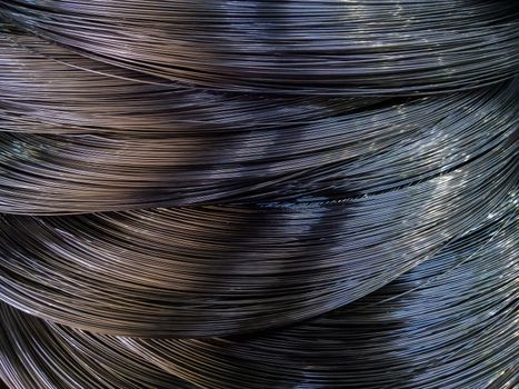 Closeup background of metal wire roll in silver color. Building material. Texture with selective focus and blur.