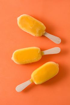 Orange popsicles on orange background