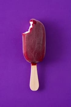 Strawberry popsicle on violet background.