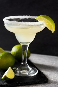 Margarita cocktails with lime in glass on gray background. Copyspace